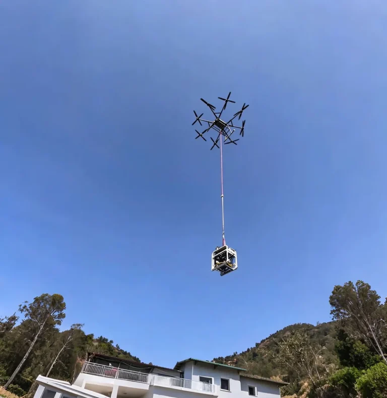 Heavy-lift drone delivering a payload to a hillside house