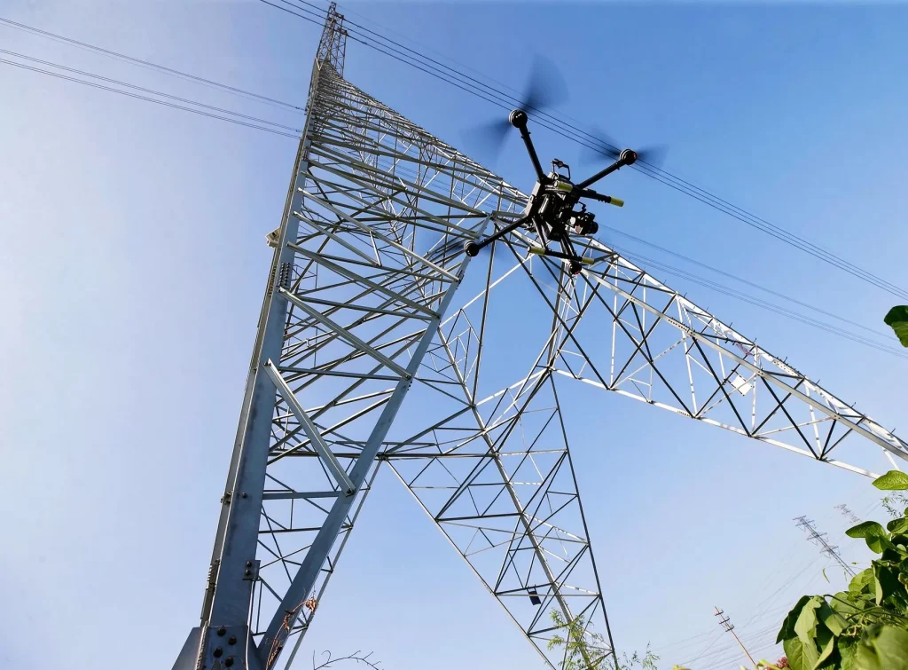 Drone inspecting a high-voltage transmission tower